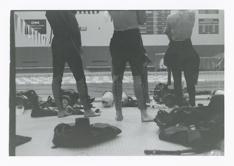 Image of the backs of thee people's legs as they observe a demonstration in the pool. Photo by Kirsten DeZeeuw